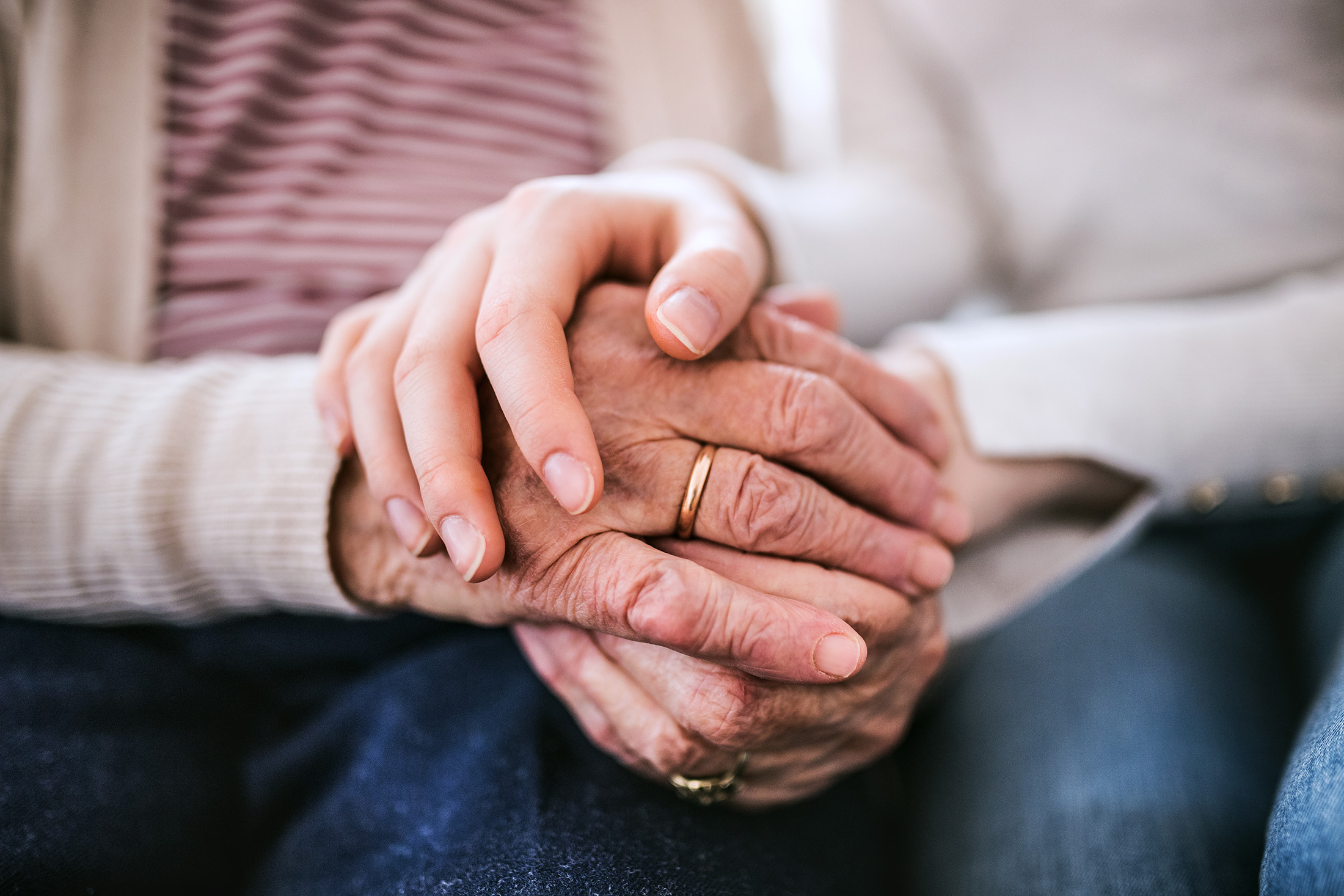 Hands of teenage girl and her grandmother at home.