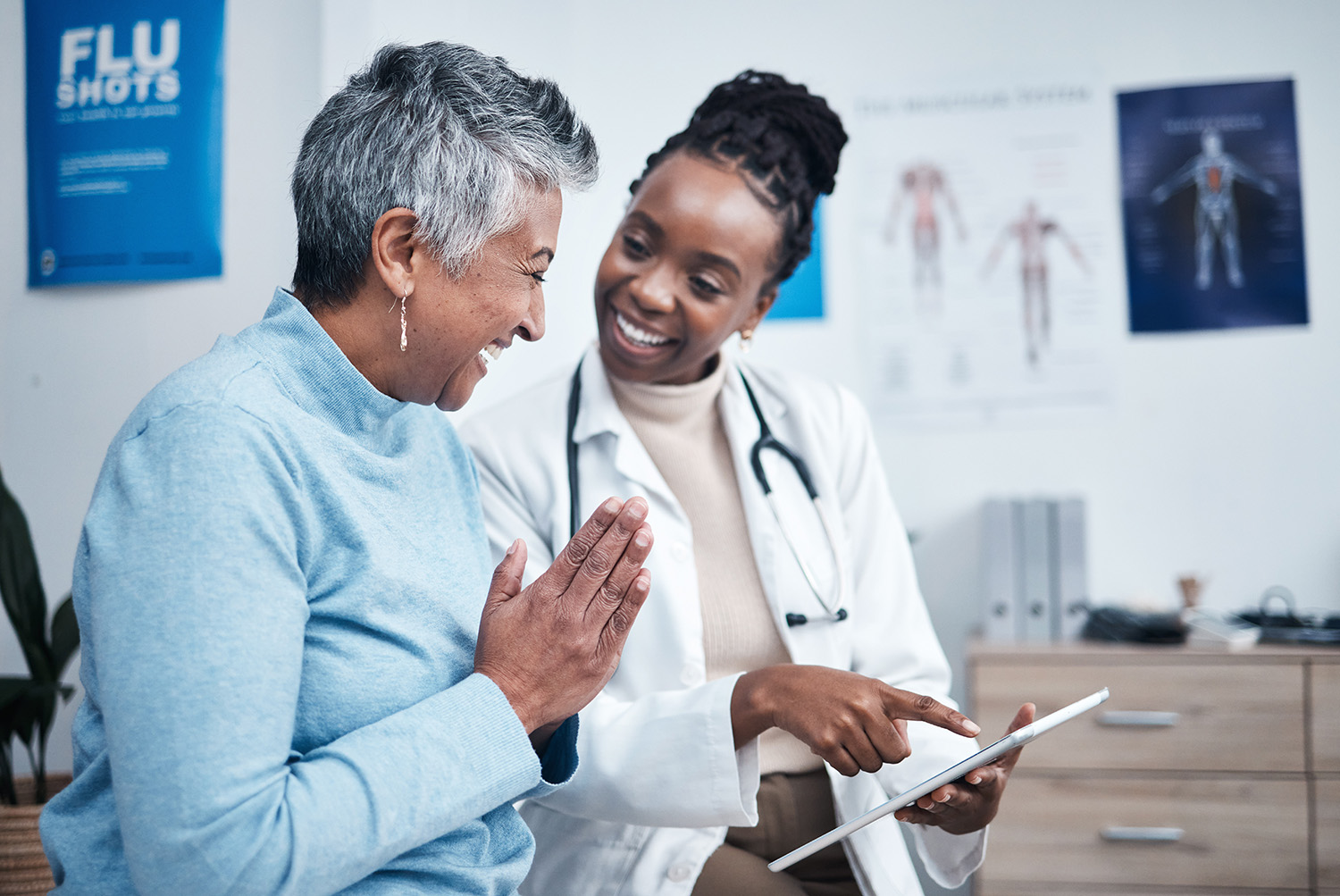 Happy elderly woman speaking with her doctor while looking at test results