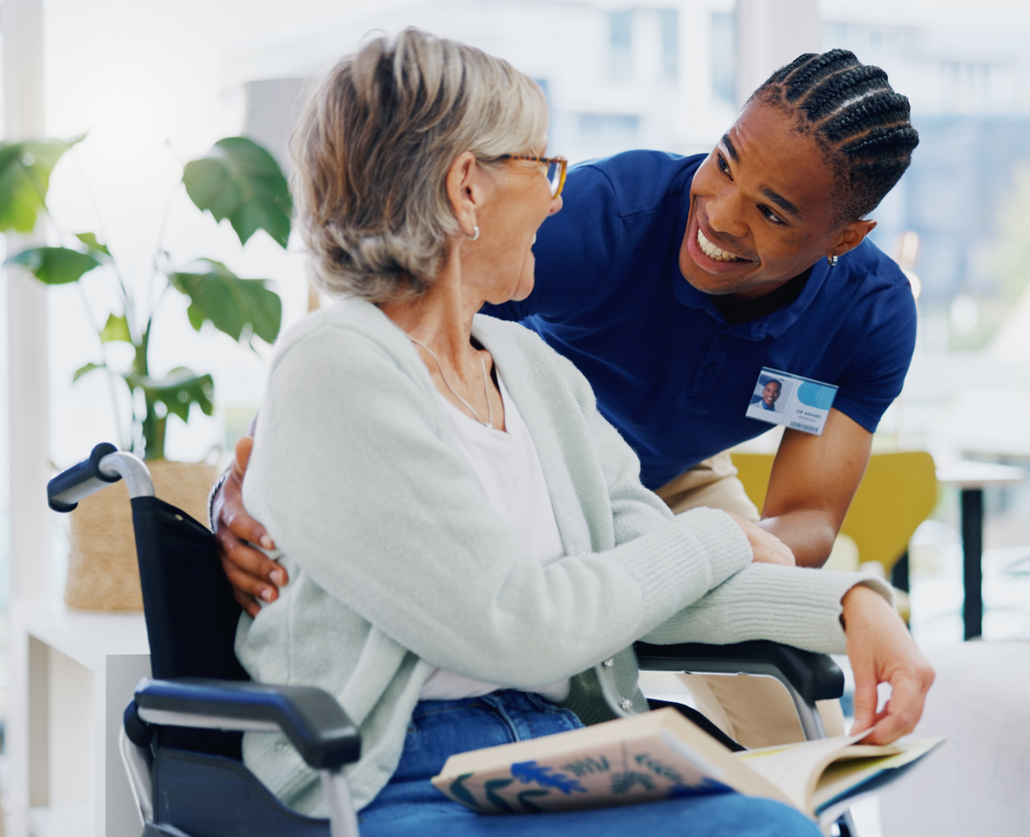 Caregiver helping an elderly woman as they smile warmly